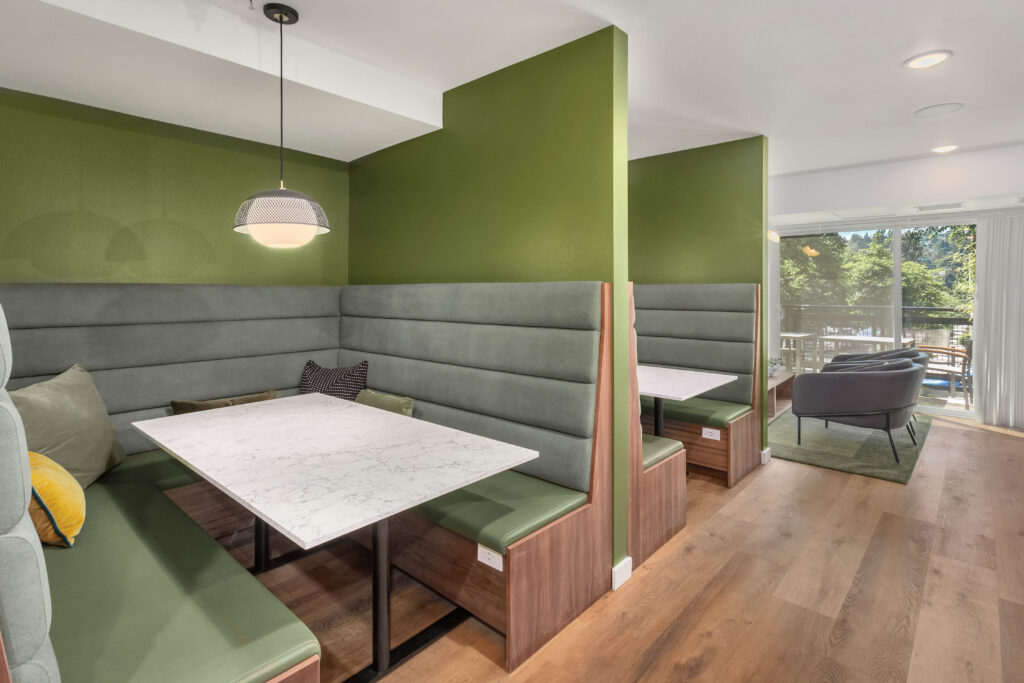 Green booth seating in the co-working lounge at Contour Apartments